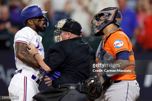 Adolis Garcia of the Texas Rangers argues with Martin Maldonado of the Houston Astros after being hit by a pitch by Bryan Abreu of the Houston Astros...