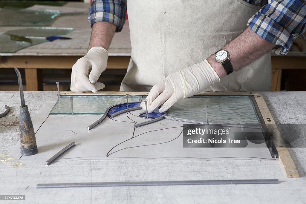 Stained glass window being pieced together.