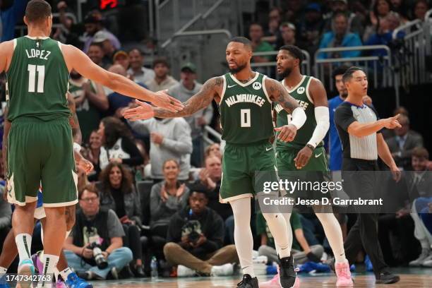 Damian Lillard high fives Brook Lopez of the Milwaukee Bucks during the game against the Philadelphia 76ers on October 26, 2023 at the Fiserv Forum...