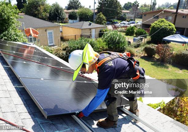 Alternatives employee Tony Chang installs no-cost solar panels on the rooftop of a low-income household on October 19, 2023 in Pomona, California....