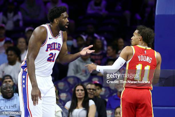 Joel Embiid of the Philadelphia 76ers and Trae Young of the Atlanta Hawks react during the first quarter at the Wells Fargo Center on October 20,...