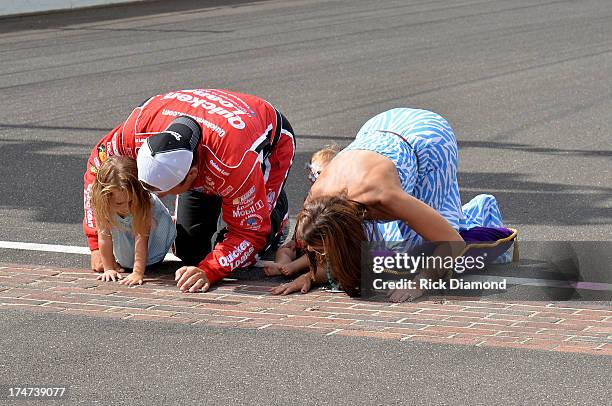 Nascar driver Ryan Newman celebrates after winning with his wife Krissie Newman and daughters by kissing the bricks at the Brickyard 400 Presented By...