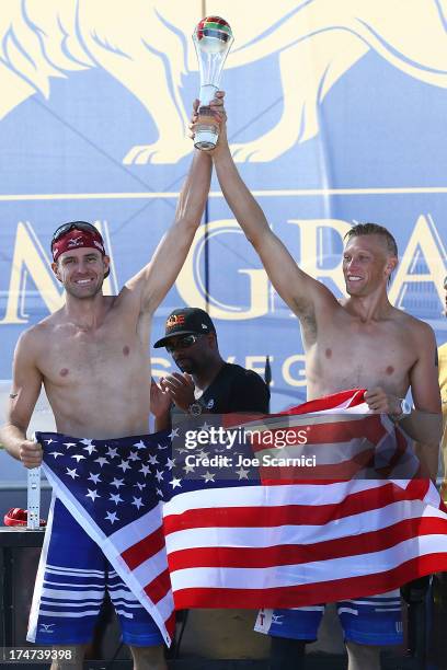 Jake Gibb and Casey Patterson hoist the trophy on stage after winning the men's final match at the ASICS World Series Cup - Day 2 on July 28, 2013 in...
