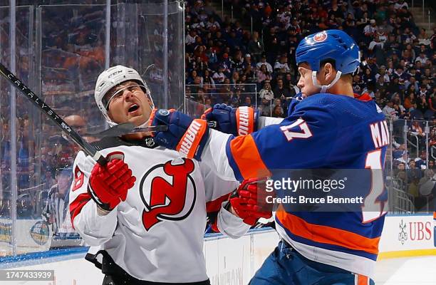 Matt Martin of the New York Islanders gets called for cross-checking Timo Meier of the New Jersey Devils during the second period at UBS Arena on...