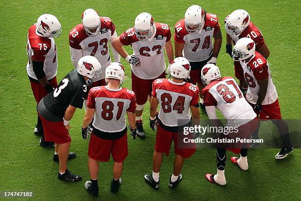 Quarterback Carson Palmer of the Arizona Cardinals huddles up with teammates during the team training camp at University of Phoenix Stadium on July...