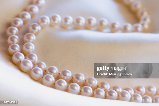 pearls on cream silk - parel stockfoto's en -beelden