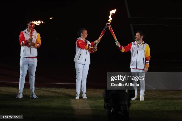 Chilean swimmer Kristel Köbrich hands the Pan American torch to Chilean Gymnast Tomás Gonzalez during the opening ceremony of the Santiago 2023 Pan...