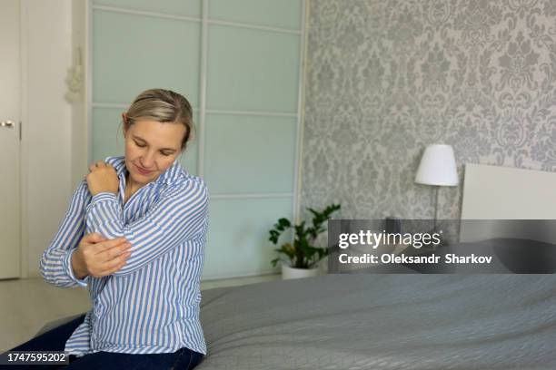 young woman with elbow pain, diagnosed as tennis elbow - verrenkung stock-fotos und bilder