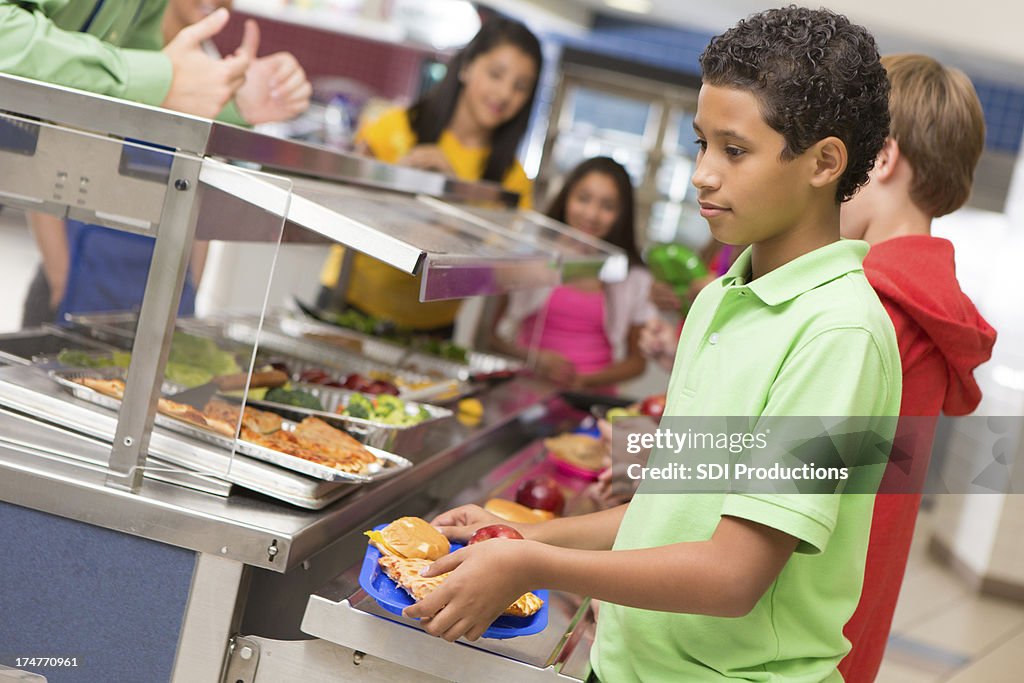 Middle school students getting lunch items in cafeteria line