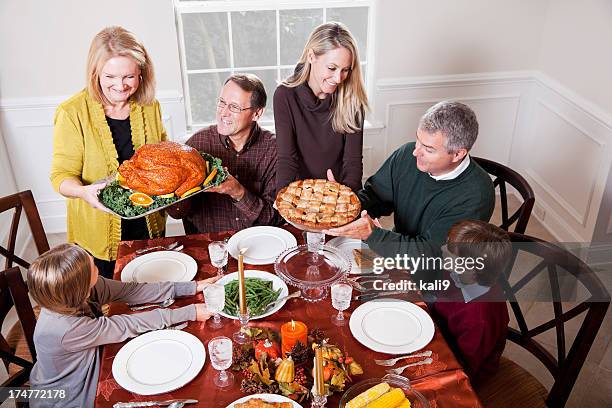 multi-generation family enjoying traditional holiday dinner - american pie reunion stock pictures, royalty-free photos & images