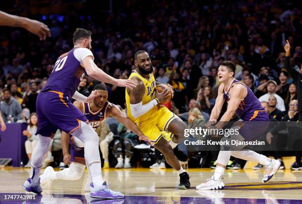 LeBron James of the Los Angeles Lakers drives to the basket as he is triple teamed by Jusuf Nurkic, Grayson Allen and Eric Gordon of the Phoenix Suns...