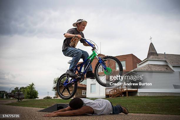 Fielding , jumps over Zach on July 28, 2013 in Alexander, North Dakota. Fielding's dad, who works as a mechanic and welder, moved the family to North...