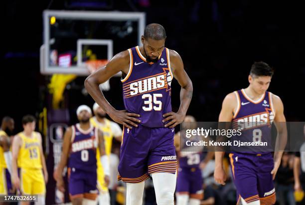 Kevin Durant of the Phoenix Suns, who scored a game high 39 points, and Grayson Allen look dejected as they walk off the court in the closing seconds...