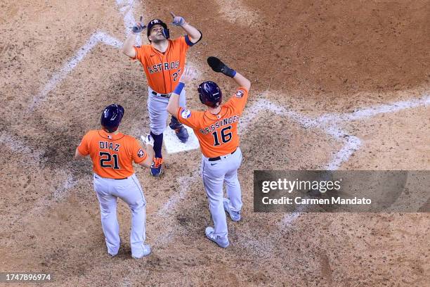 Jose Altuve of the Houston Astros celebrates with Yainer Diaz and Grae Kessinger after hitting a three run home run against Jose Leclerc of the Texas...