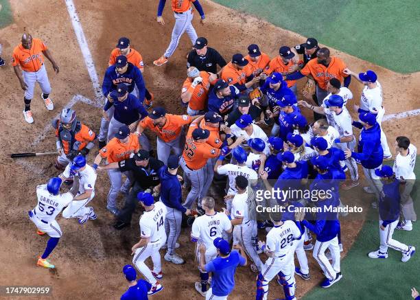 Adolis Garcia of the Texas Rangers argues with Martin Maldonado of the Houston Astros after being hit by a pitch by Bryan Abreu of the Houston Astros...