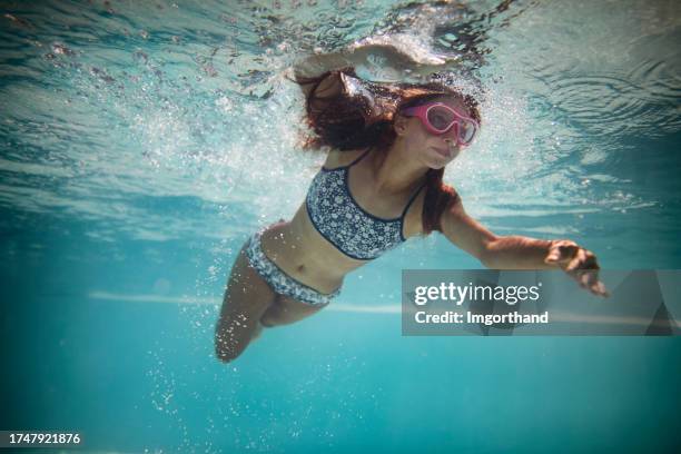 underwater portrait of a teenage girl swimming in a swimming pool - alton staffordshire stock pictures, royalty-free photos & images