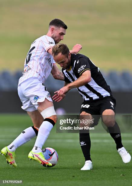 James O'Shea of Brisbane Roar and Valere Germain of Macarthur FC compete for the ball during the A-League Men round one match between Macarthur FC...