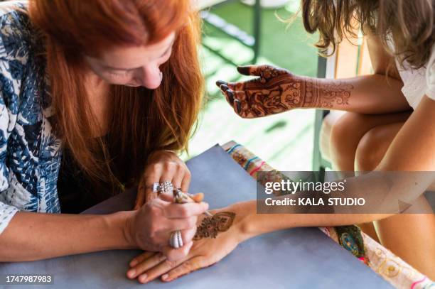 tattoo artist drawing a mehndi pattern with henna - tatuagem de henna imagens e fotografias de stock