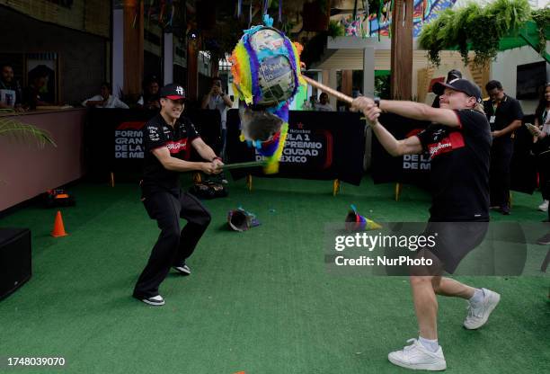 Guanyu Zhou , driver of the Alfa Romeo Team; and Valtteri Bottas , driver of the Alfa Romeo Team, break a pinata during activities prior to the first...