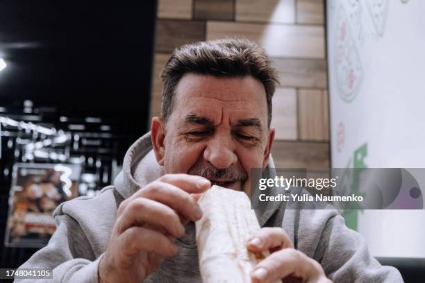 an adult man eating shawarma. - turkey burger stock pictures, royalty-free photos & images