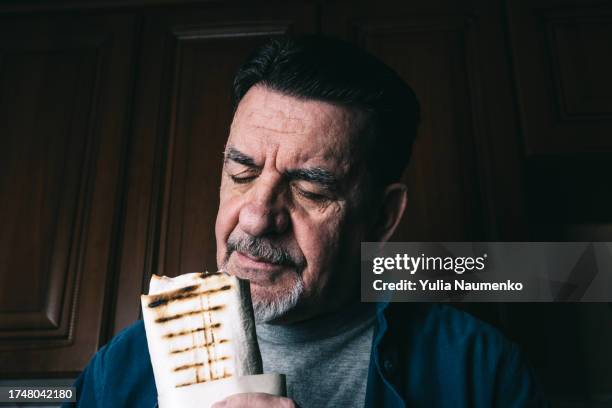 an adult man eating shawarma. - turkey burger stock pictures, royalty-free photos & images