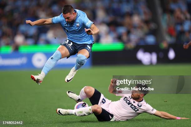 Róbert Mak of Sydney FC is tackled by Bruno Mezza of the Victory during the A-League Men round one match between Sydney FC and Melbourne Victory at...