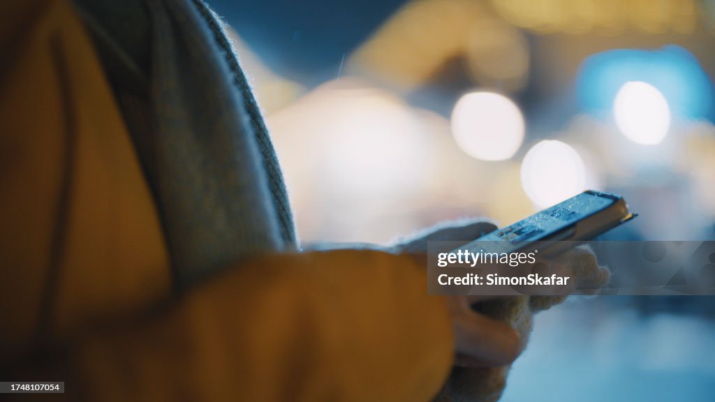 Close-up of woman in warm clothing using mobile phone