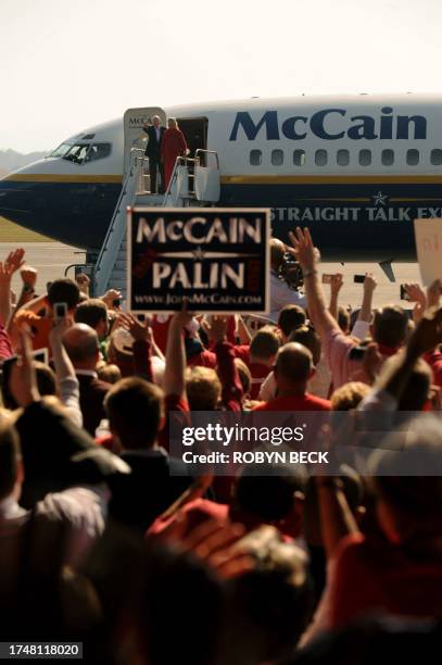 Supporters cheers as Republican presidential candidate Arizona Senator John McCain and his wife Cindy wave as they emerge from the campaign plane...