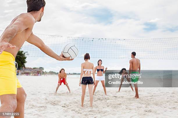 jovens amigos jogando vôlei na praia - beach volleyball - fotografias e filmes do acervo