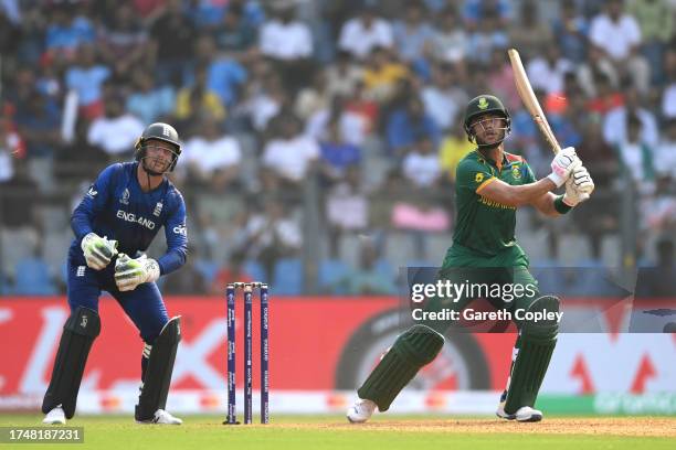 Reeza Hendricks of South Africa hits a six as Jos Buttler of England looks on during the ICC Men's Cricket World Cup India 2023 match between England...