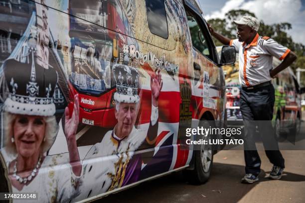 Man inspects a van set to be part of the royals' convoy and decorated by Kenyan artists with symbolic designs representing the UK and Kenya at a bus...