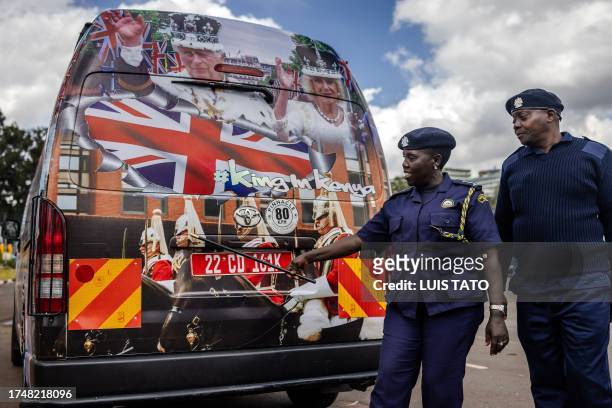Nairobi inspection officers check a van set to be part of the royals' convoy and decorated by Kenyan artists with symbolic designs representing the...