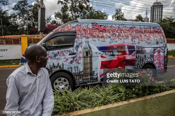 Man observes a van set to be part of the royals' convoy and decorated by Kenyan artists with symbolic designs representing the UK and Kenya at a bus...