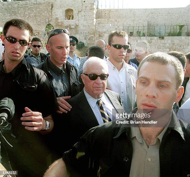 Israeli security officers guard then-opposition leader Ariel Sharon September 28, 2000 as he leaves the Temple Mount compound in east Jerusalem's Old...