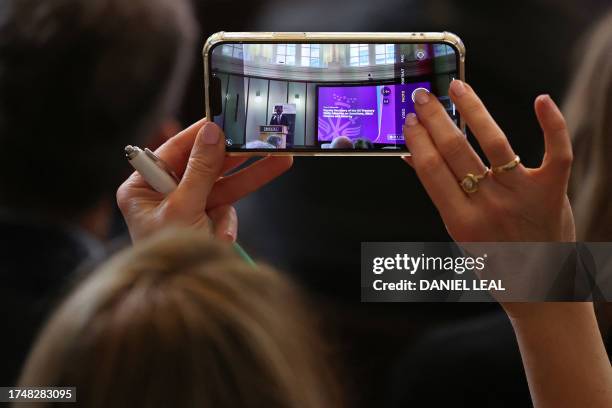 Deputy Treasury Secretary Wally Adeyemo is seen on the screen of a smartphone as he delivers a speech outlining the new action taken by the US...