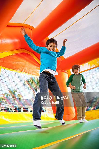 boys in bounce house - inflatable playground stock pictures, royalty-free photos & images