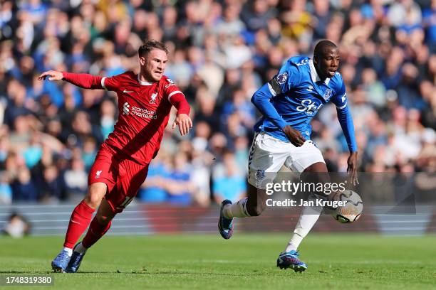 Abdoulaye Doucoure of Everton runs with the ball whilst under pressure from Alexis Mac Allister of Liverpool during the Premier League match between...