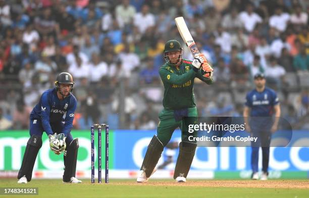 Heinrich Klaasen of South Africa bats as wicket keeper, Jos Buttler of England looks on during the ICC Men's Cricket World Cup India 2023 match...