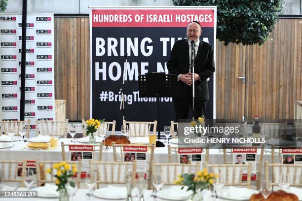 Chief Rabbi of the United Hebrew Congregations of the Commonwealth, Ephraim Mirvis speaks to the empty places laid out for the 220 hostages at a...