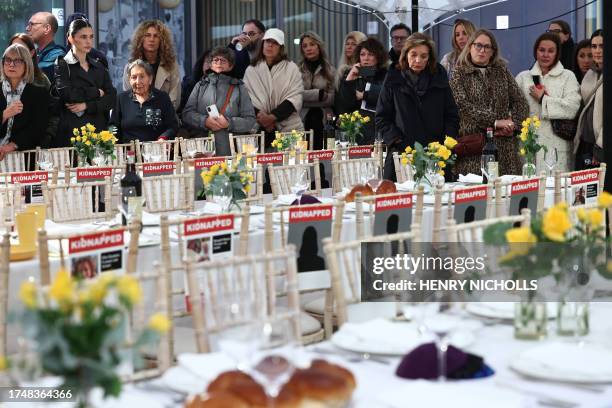 People come to view the empty places laid out for the 220 hostages at a 'Shabbat' table in the JW3 Piazza in north London on October 27 as people are...