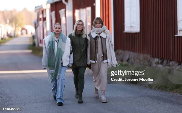 Michi Brandl seen wearing a Copenhagen Studios pastel green checked oversized wool knit scarf, white fluffy gilet, grey cotton hoodie / sweatshirt,...