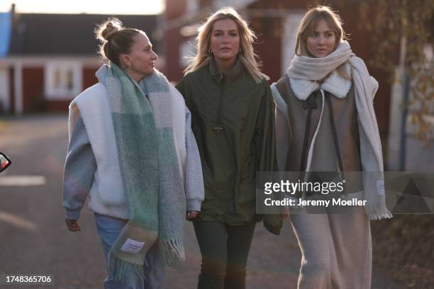 Michi Brandl seen wearing a Copenhagen Studios pastel green checked oversized wool knit scarf, white fluffy gilet, grey cotton hoodie / sweatshirt,...