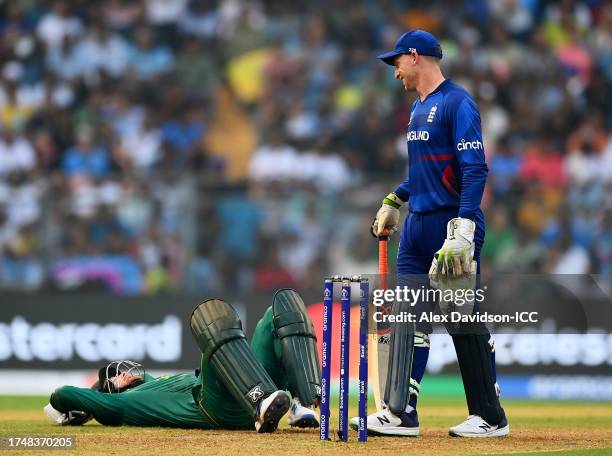 Heinrich Klaasen of South Africa goes down injured as Jos Buttler of England reacts during the ICC Men's Cricket World Cup India 2023 match between...