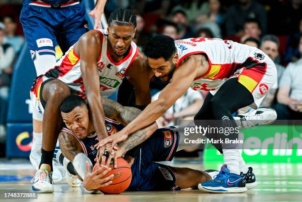 Jacob Wiley of the 36ers competes with Corey Webster and Alexandre Sara of the Wildcats during the round four NBL match between Adelaide 36ers and...