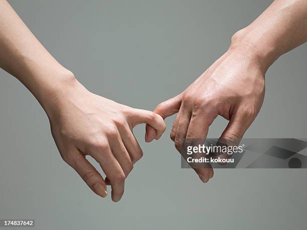 meñique s'ató. - couple holding hands fotografías e imágenes de stock
