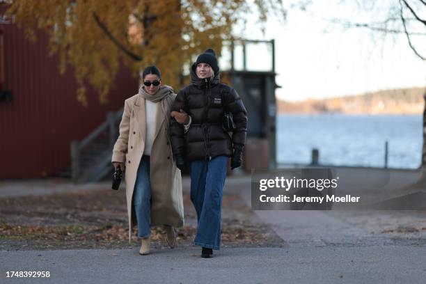 Benthe Liem seen wearing gold earrings, black sunglasses, beige wool knit scarf, white cream wool knit pullover, beige long coat, brown suede leather...