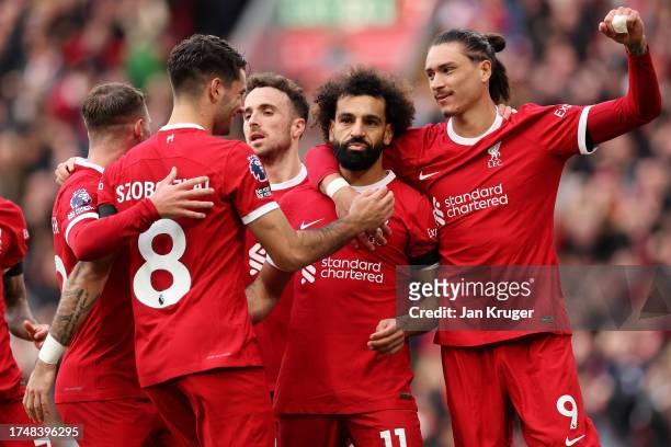 Mohamed Salah of Liverpool celebrates with teammates after scoring the team's first goal during the Premier League match between Liverpool FC and...