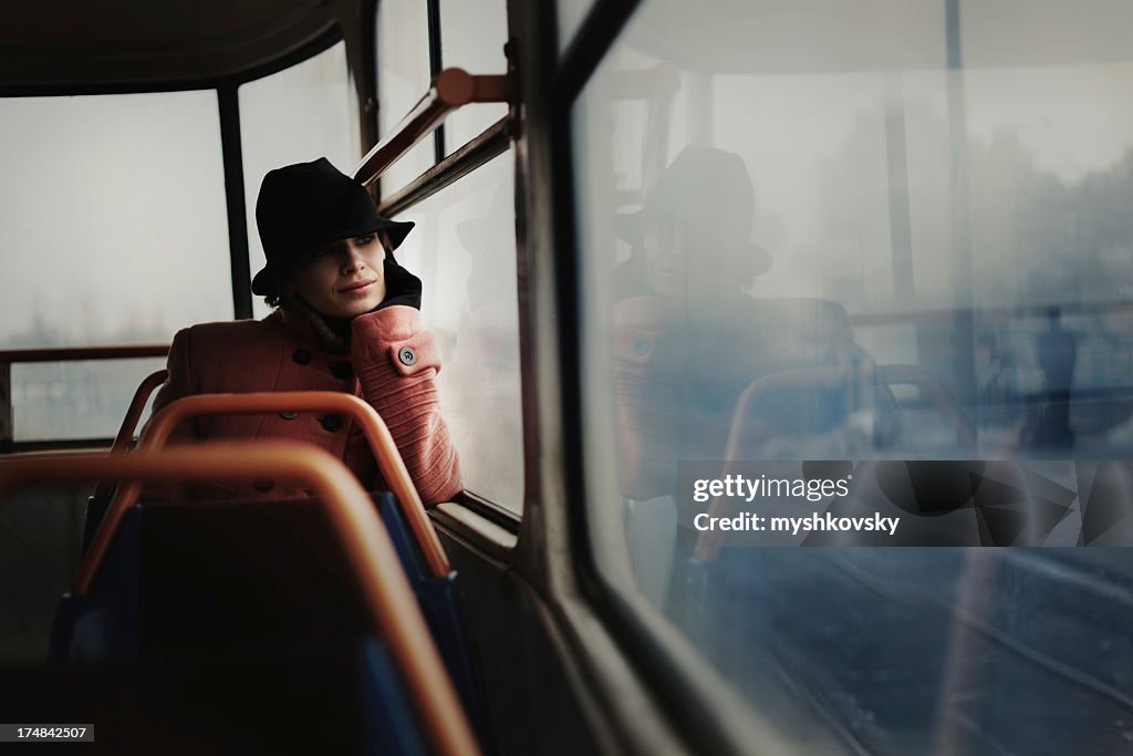 Lone woman in a train car looking off into the distance