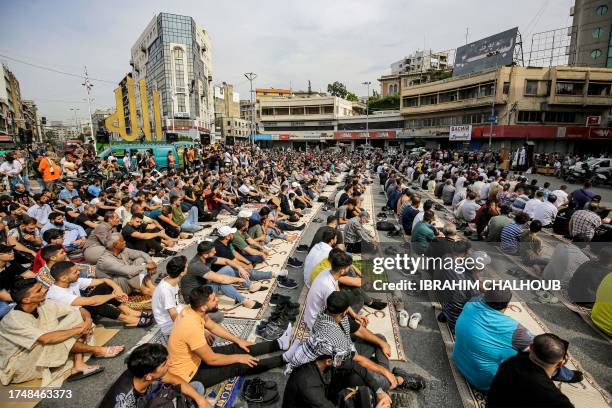 Muslim worshippers gather for the weekly Friday noon prayers at Nour Square in Lebanon's northern city of Tripoli on October 27 ahead of a rally in...