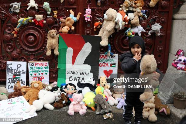 Young children bring teddy bears and other soft toys representing children killed in Gaza, to the gates of the Foreign, Commonwealth and Development...